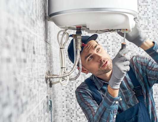 A technician installs a water heater.