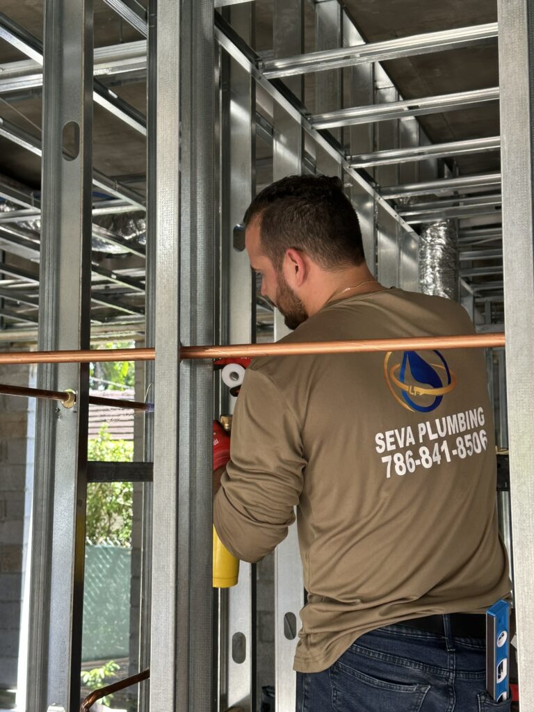Plumber installing copper pipes indoors